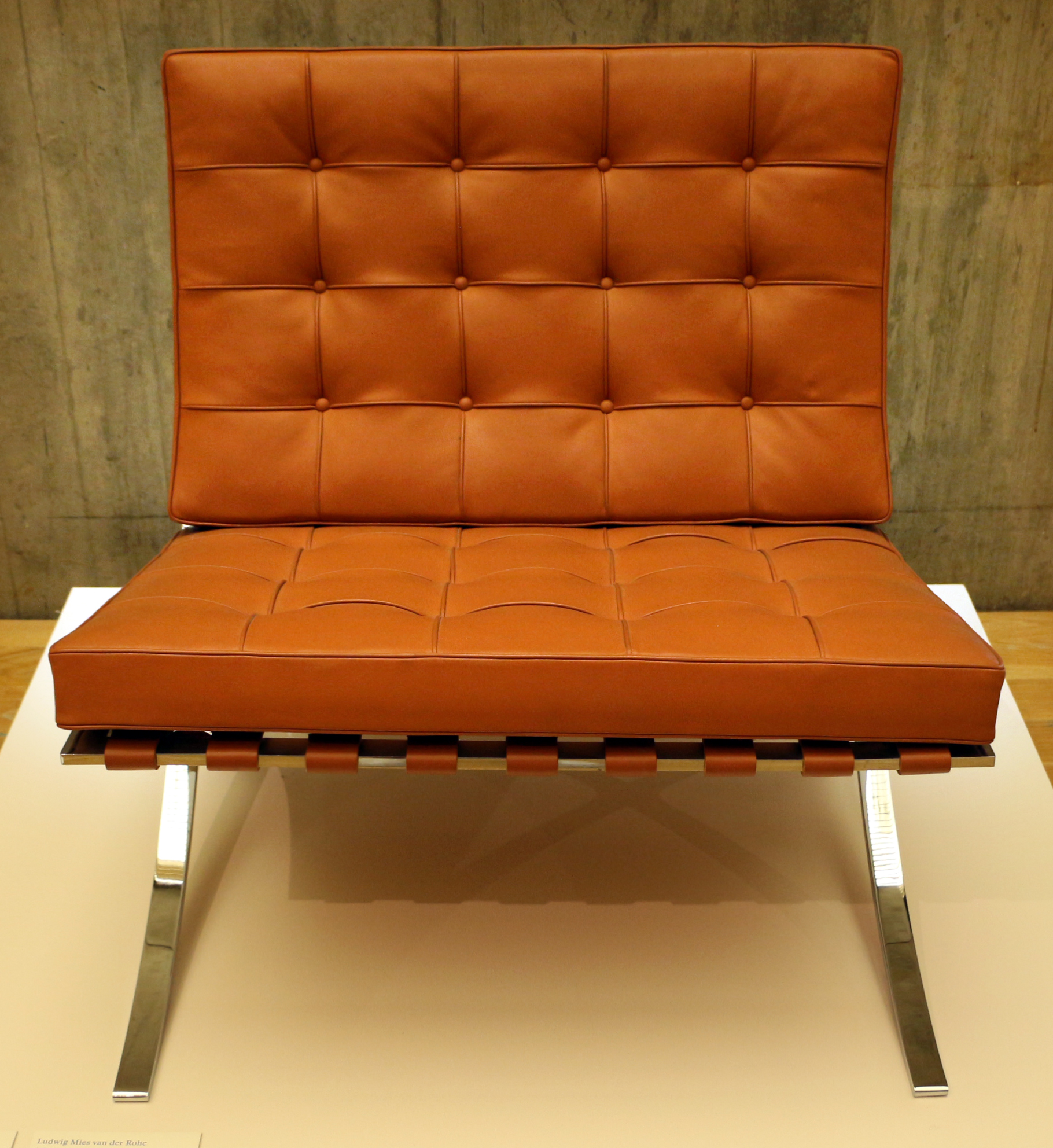 Front three-quarter view of a Barcelona Chair highlighting the curved X-frame structure